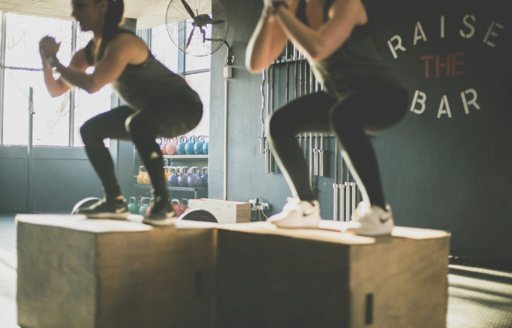 runners doing box jumps in gym